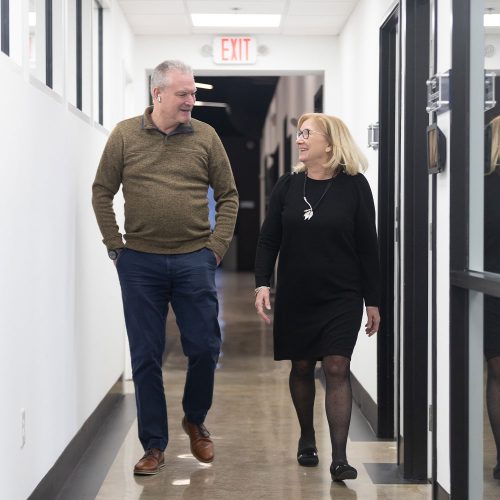 Man and woman walking down the CDS office hallway