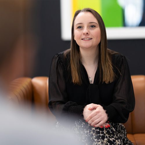 CDS employee sitting on a couch, smiling