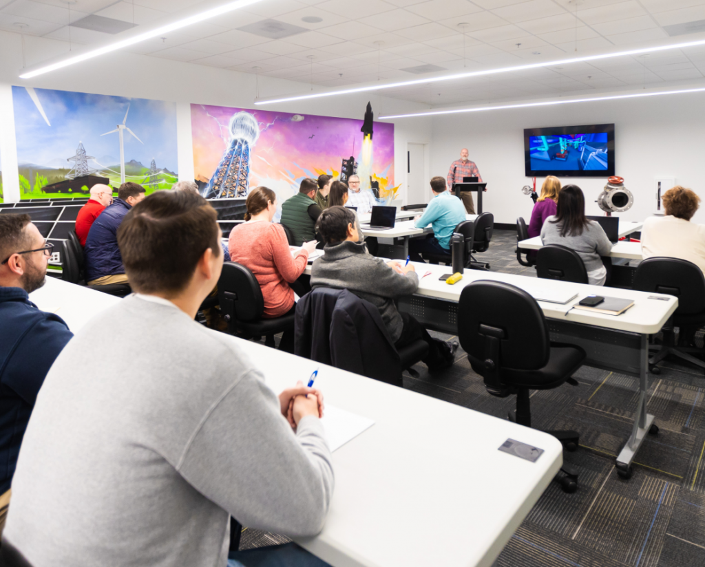 Man presenting to a room of CDS employees at the office