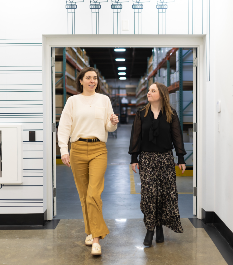 Two women walking through the CDS office